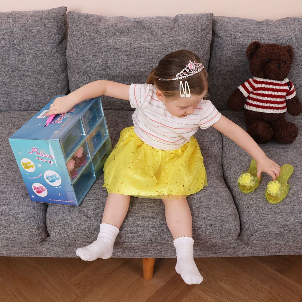 A girl in a sofa with the princess role play dress up skirts and play shoes box