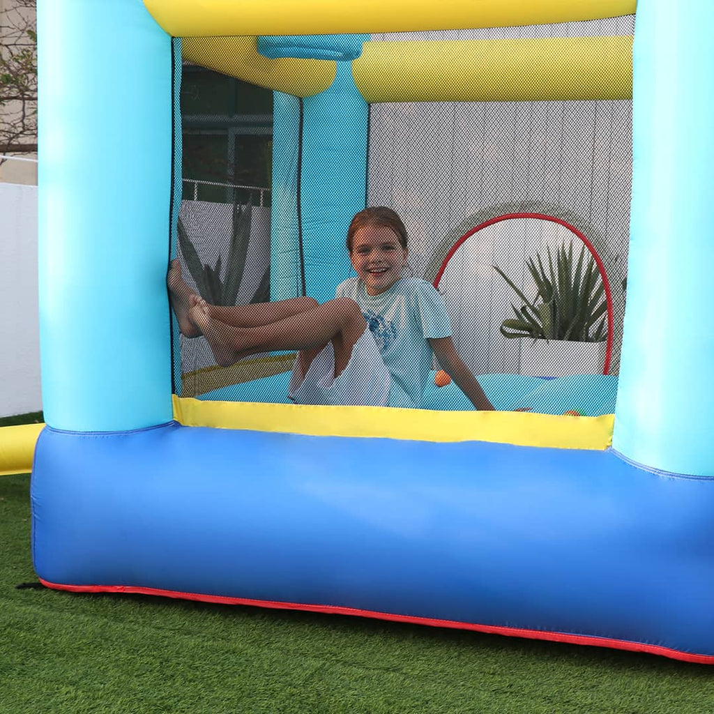 A girl happily playing inside the inflatable unicorn bounce house with blower and slide