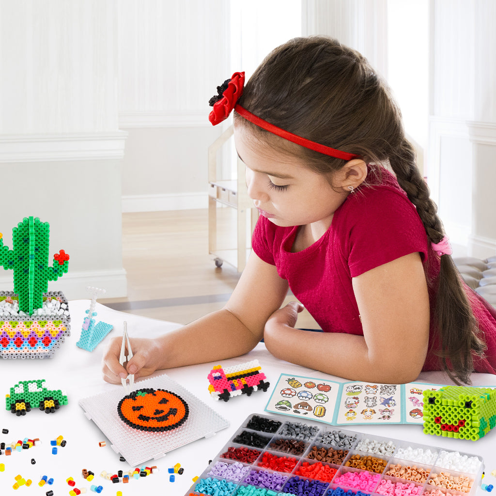 A little girl playing with the fuse beads kit for kids 