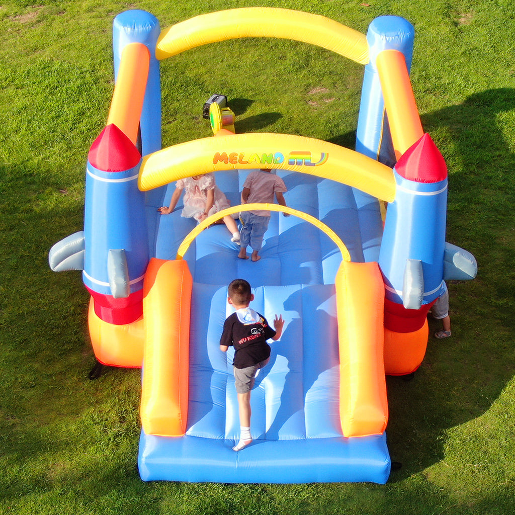 Several kids playing with the bounce house